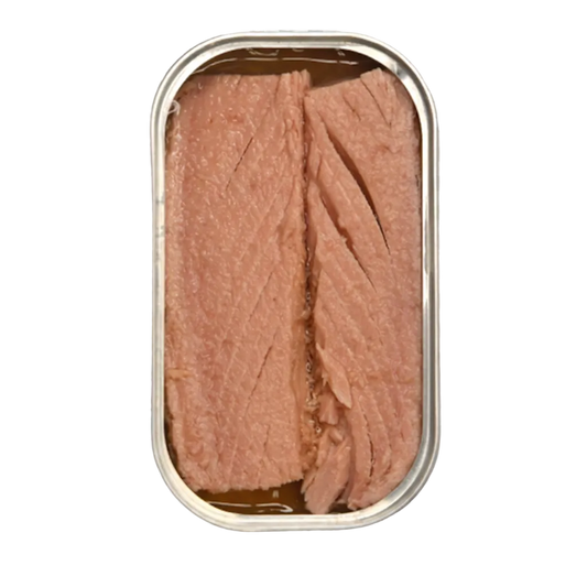 An open metal can of sliced pink fish, likely tuna, showing the flaky texture of the meat inside, isolated on a gray and white checkered transparency background.