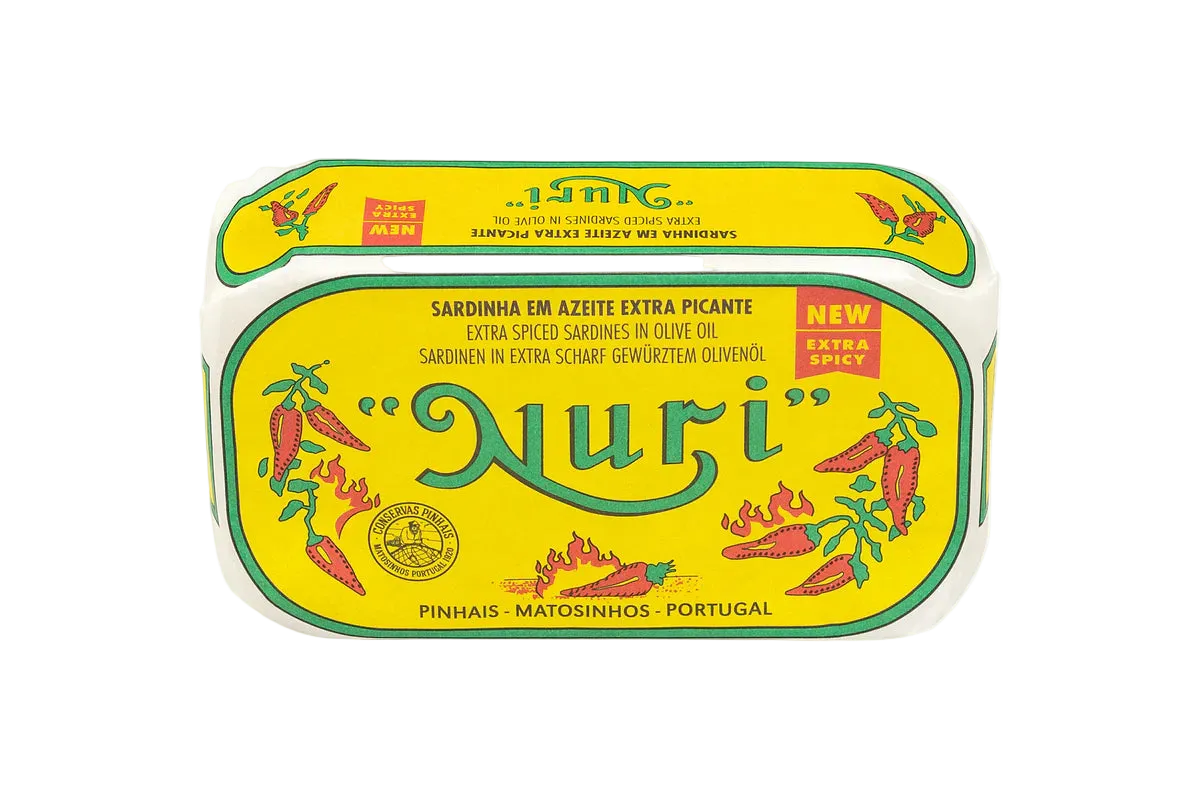 A tin of Nuri extra spicy sardines in olive oil, featuring a bright yellow label with green borders, red chili pepper illustrations, and the brand name 'Nuri' in large green script.